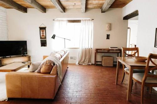 Group Getaway: Serene Adobe Retreat 4-11 guests في ألباكيركي: غرفة معيشة مع أريكة وطاولة