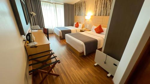 a hotel room with two beds and a television at Lake Titicaca Hotel in Puno