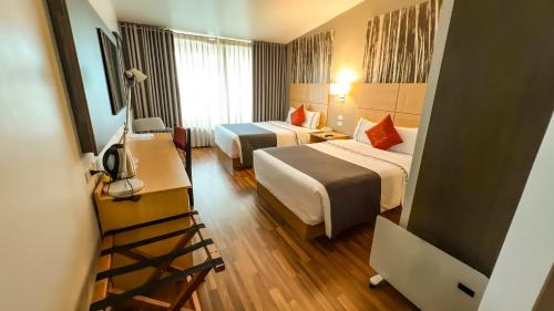 a hotel room with two beds and a television at Lake Titicaca Hotel in Puno