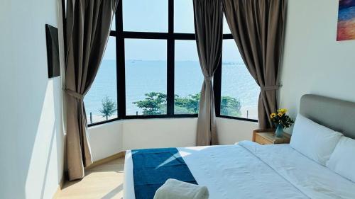 a bedroom with a bed and a large window at Mutiara Melaka Beach Paradise by Glex in Tangga Batu