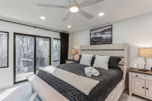 1 dormitorio con 1 cama grande y ventilador de techo en RiverEdge Haven Hot Tub, 5 Beds, Kayaks Near ND, en Niles