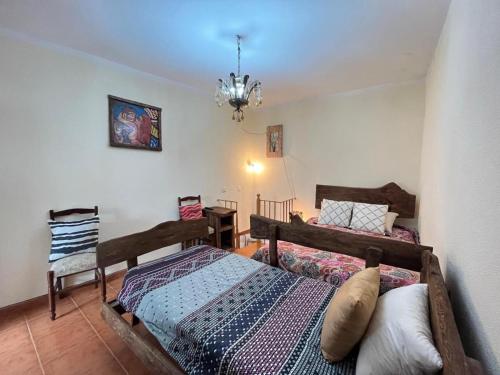 una camera con due letti e un lampadario a braccio di Cosy Home Near Serra da Estrela a Gouveia