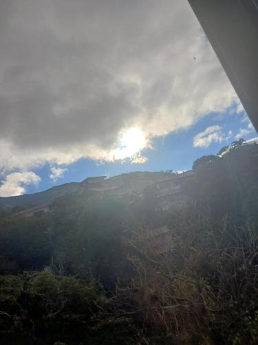 a view of a mountain with the sun in the sky at Habitaciones el mirador in San José