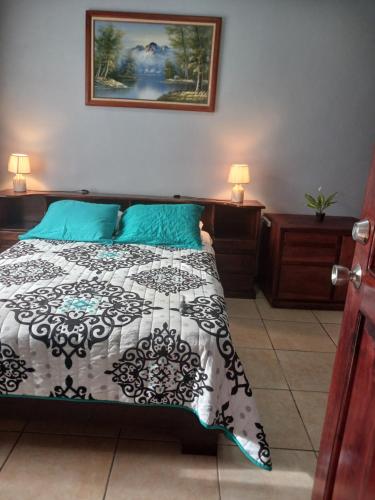 a bedroom with a bed with a black and white comforter at Habitaciones el mirador in San José