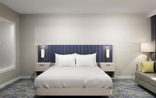 a bedroom with a large bed and a couch at EVEN Hotels Waco - University Area, an IHG Hotel in Waco