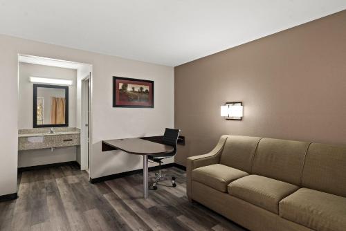 a living room with a couch and a desk with a laptop at Red Roof Inn Spartanburg - I-85 in Spartanburg