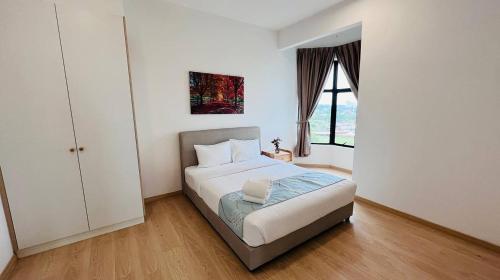 a white bedroom with a bed and a window at Mutiara Melaka Beach Paradise by Glex in Tangga Batu