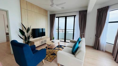 a living room with two chairs and a television at Mutiara Melaka Beach Paradise by Glex in Tangga Batu
