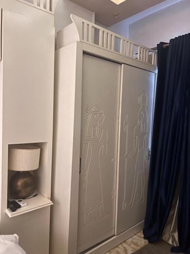 a bedroom with a bunk bed with a door with drawings on it at Pyramids Top Inn in Cairo