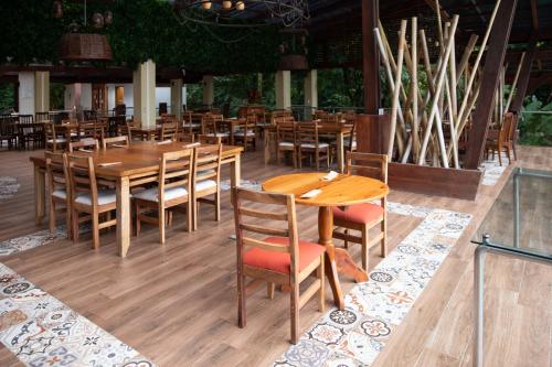 een eetkamer met houten tafels en stoelen bij Pachira Lodge in Tortuguero