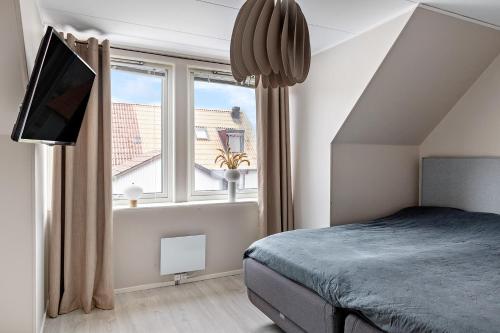um quarto com uma cama e uma grande janela em Radhus med 5 min bilavstånd till centrum & strand em Halmstad