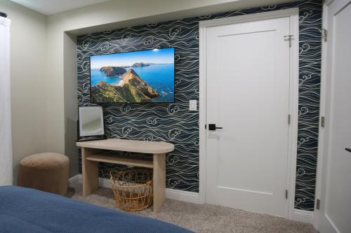 a bedroom with a desk and a painting on a wall at Luxury Beach Home - Steps to the Sand, Game Room, Firepit, Deck in Oxnard