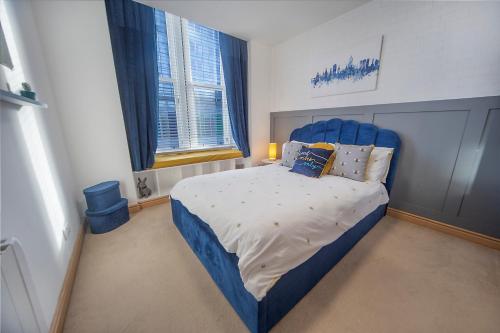 een slaapkamer met een blauw bed met een blauw hoofdeinde bij Guild Street Apartment ✪ Grampian Lettings Ltd in Aberdeen