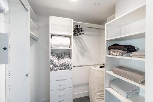 a white walk in closet with white shelves at Fully Furnished Apartments near Hollywood Walk of Fame in Los Angeles