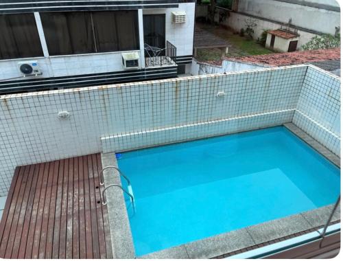 a large blue swimming pool with a tiled roof at Apartamento na praia do Recreio - Posto 10 in Rio de Janeiro