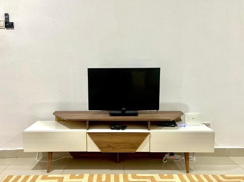 a tv sitting on top of a white entertainment center at Damai Homestay Kuala Krai in Kuala Kerai