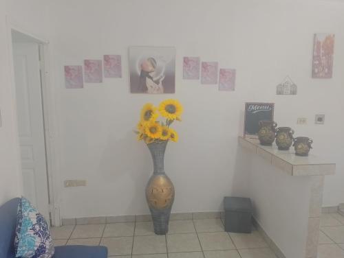 eine Vase mit Sonnenblumen an einer Wand mit Bildern in der Unterkunft MI HOGAR in Tegucigalpa
