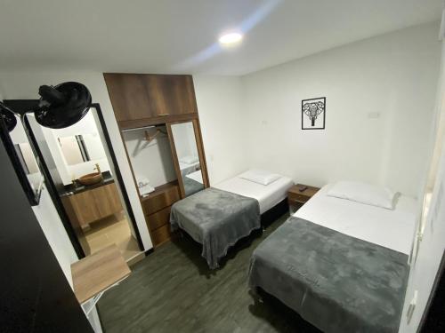 a hotel room with two beds and a mirror at Bramasole Hotel Boutique - El Peñol in El Peñol