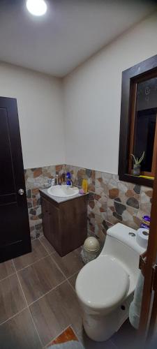 a bathroom with a toilet and a sink at Rancho Valle del Rio in Cuenca