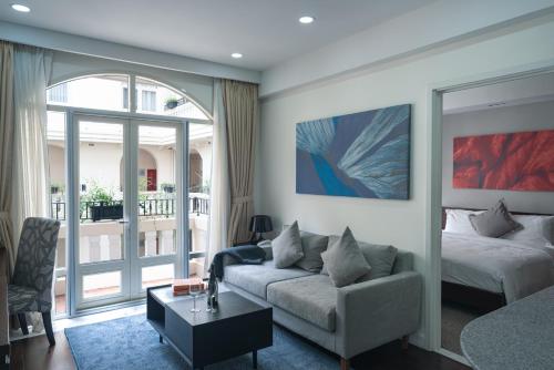 a living room with a couch and a bed at Central Mansions Serviced Apartments in Phnom Penh