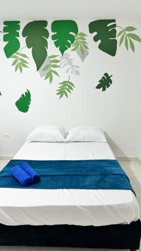 1 dormitorio con 1 cama con hojas en la pared en Marbar Cartagena Hostel, en Cartagena de Indias