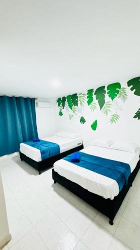 two beds in a room with blue and green wallpaper at Marbar Cartagena Hostel in Cartagena de Indias