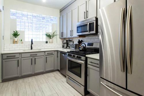 a kitchen with stainless steel appliances and a refrigerator at 4 Bedroom Sun Drenched & Designer Home in Brooklyn