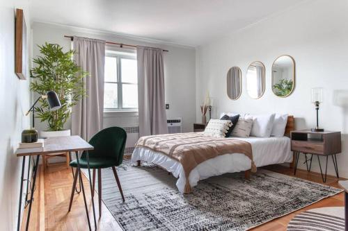 a bedroom with a bed and a table and a chair at 4 Bedroom Sun Drenched & Designer Home in Brooklyn