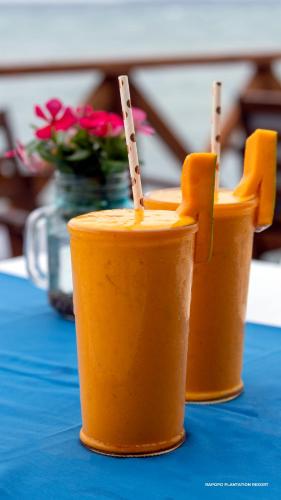 three orange cups sitting on top of a blue table at Rapopo Plantation Resort in Kokopo