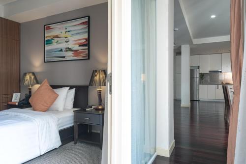 a bedroom with a bed and a table with a lamp at Central Mansions Serviced Apartments in Phnom Penh