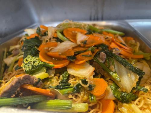 a bowl of food with noodles and vegetables at Hotel Hoa Nắng in Bao Loc