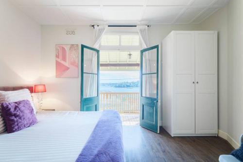 a bedroom with a bed with blue doors and a window at Water front - KING 3 Room Rooftop The Rocks #E2 in Sydney