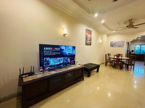 sala de estar con TV de pantalla plana grande en Landed 4BR 11PAX Near Airport KK, en Putatan