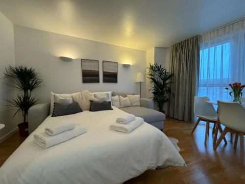a bedroom with a large white bed with towels on it at Luxury Apartment in Canary Wharf in London