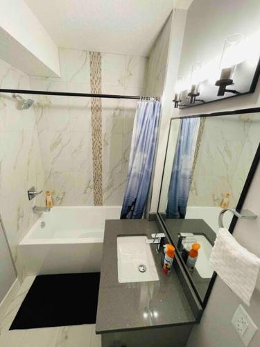 a bathroom with a sink and a bath tub at Cozy*Bright*Modern 2 Bedroom guest suite in Edmonton