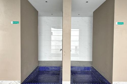 baño con suelo de baldosa azul y puerta de cristal en Yussy Homestay at Carnelian Tower Forest City, en Gelang Patah