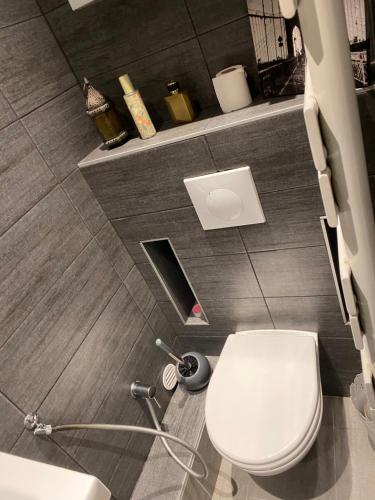 een badkamer met een wit toilet en een wastafel bij Le Saint-Brice de Paris in Saint-Brice-sous-Forêt