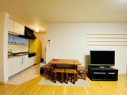 a living room with a table and a kitchen at Hirafu House 8 in Kutchan