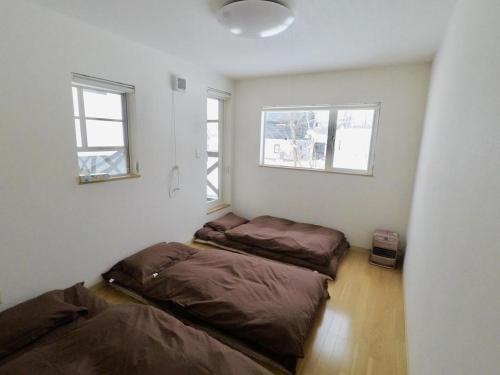 two beds in a room with two windows at Hirafu House 8 in Kutchan