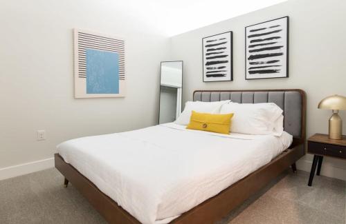 um quarto com uma cama grande e uma almofada amarela. em Cozysuites l Prime 1BR in Downtown Cincinnati em Cincinnati