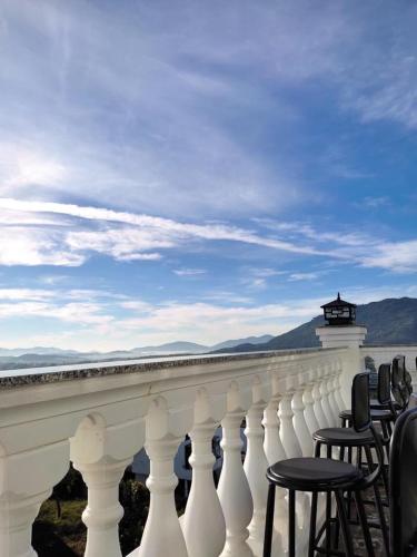 a row of chairs sitting on a white railing at Hotel Hoa Nắng in Bao Loc