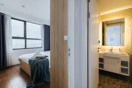 una camera con letto, lavandino e specchio di One bedroom in Vinhomes Dcapitale - Cau Giay a Hanoi
