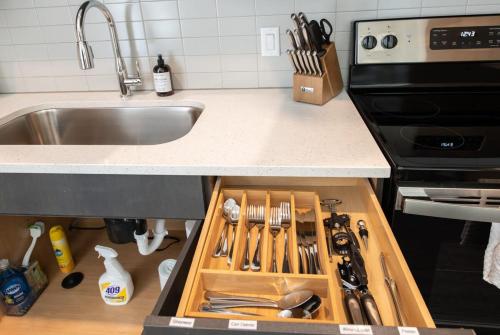 a kitchen counter with a drawer full of kitchen utensils at Cozysuites l Modern 1BR in Downtown Cincinnati in Cincinnati
