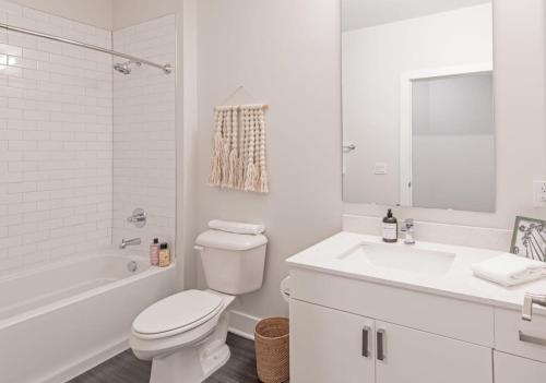 biała łazienka z toaletą i umywalką w obiekcie Cozysuites l Luxe 1BR in Downtown Cincinnati w mieście Cincinnati