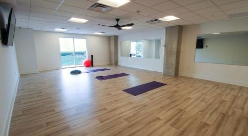 an empty room with yoga mats on a wooden floor at Cozysuites l Luxe 1BR in Downtown Cincinnati in Cincinnati