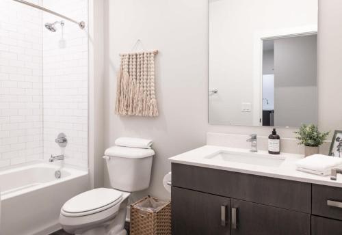 a white bathroom with a toilet and a sink at Cozysuites l Dream SDO in Downtown Cincinnati in Cincinnati