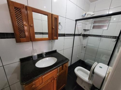 a bathroom with a sink and a toilet at CASA 50 metros DA PRAIA Matinhos in Matinhos