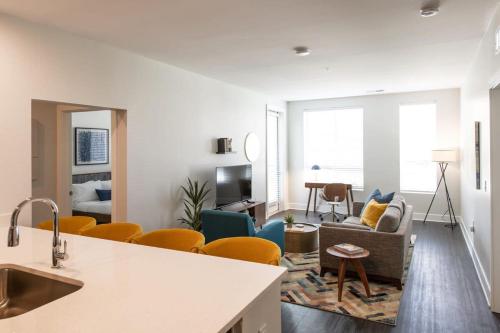 a living room with a couch and a table at Cozysuites l Luxe 2BR in Downtown Cincinnati in Cincinnati
