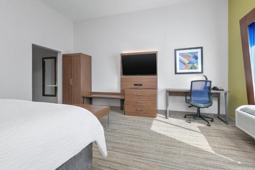 a hotel room with a bed and a desk and a television at Holiday Inn Express - San Antonio East I-10 by IHG in San Antonio