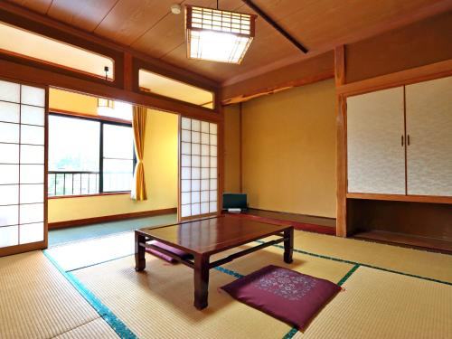 a living room with a table and windows at Sports Plaza Shiki Haradaso in Myoko